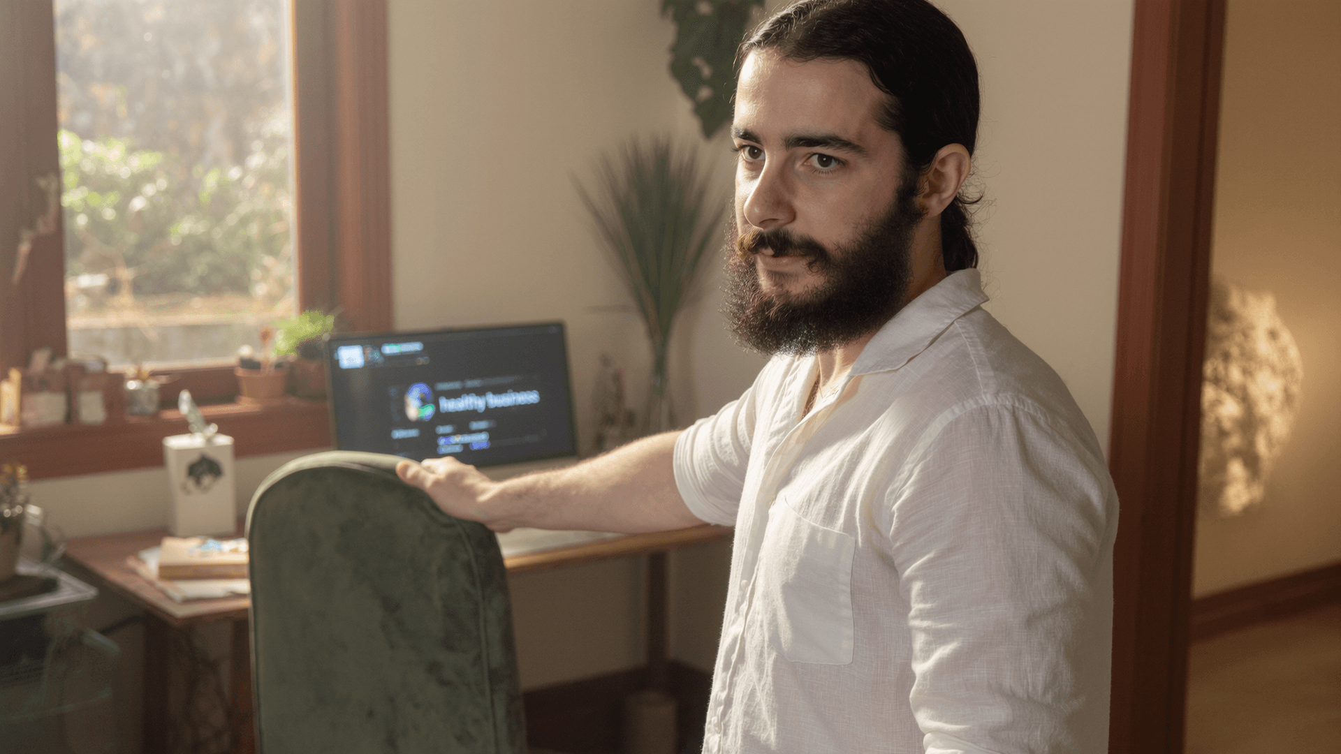 Youssef Sdiddi in his studio, screen reading 'healthy business'